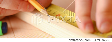 Arms of worker measuring wooden bar 47918222