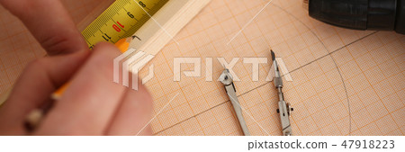 Arms of worker measuring wooden bar Arms of worker measuring wooden bar 47918223