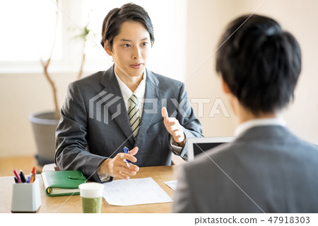 A young man who explains the size of the project with a serious expression Sales salesman Employee personnel Person in charge A young man who explains the size of the project with a serious expression Sales salesman Employee personnel Person in charge 47918303