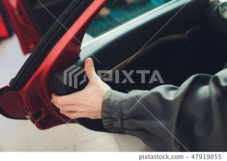 Mechanic installing car central door lock motor. 47919855