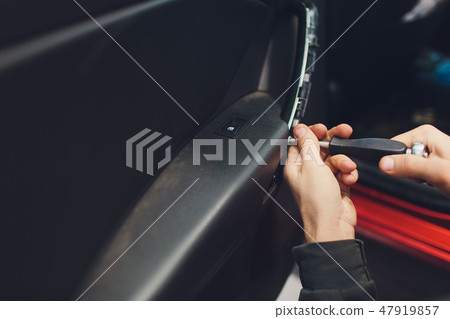 Mechanic installing car central door lock motor. 47919857