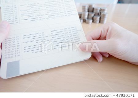 Woman hold passbook on hand, coins background Woman hold passbook on hand, coins background 47920171