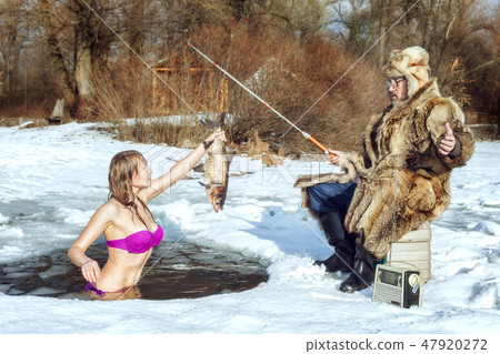Girl and elderly fisherman on winter fishing. 47920272
