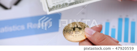 Hands with a coin bitcoin and fan of dollars Hands with a coin bitcoin and fan of dollars 47920559