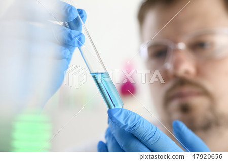 A male chemist holds test tube of glass A male chemist holds test tube of glass 47920656