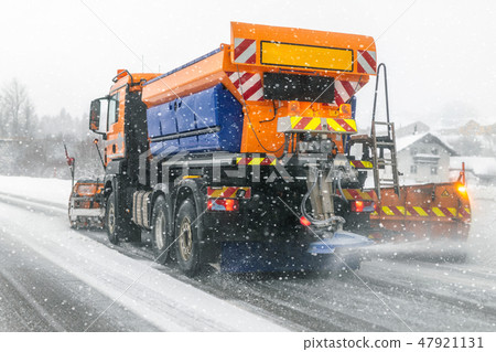 Snowplow truck removing dirty snow from city street or highway during heavy snowfalls. Traffic road 47921131