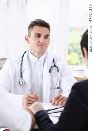 Male family doctor listen carefully young 47921330