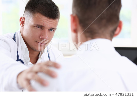 Friendly male doctor hold patient shoulder 47921331