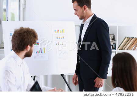 Group of people deliberate on white board Group of people deliberate on white board 47922221