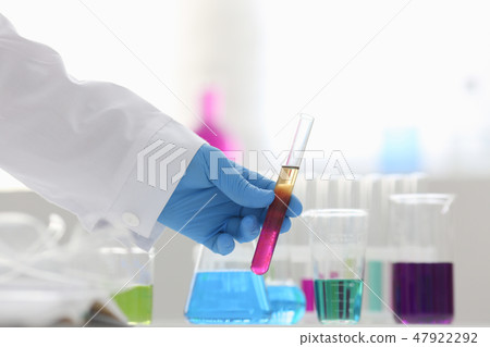 A male chemist holds test tube of glass A male chemist holds test tube of glass 47922292