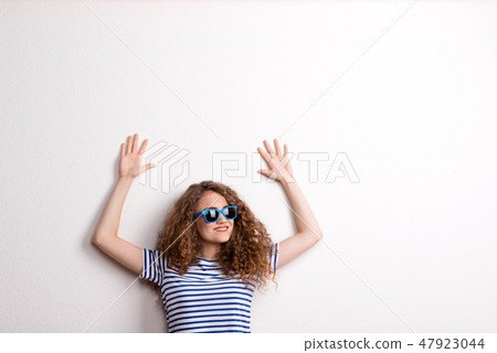 Young beautiful cheerful woman with sunglasses in studio. Copy space. 47923044