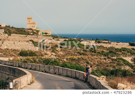 Man and woman sitting on the stone 47923286