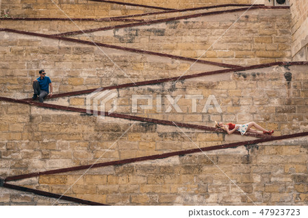 Man and woman laying on the city walls 47923723