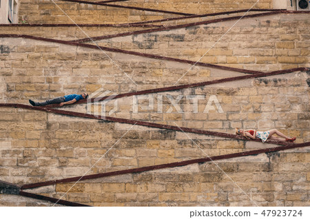 Man and woman laying on the city walls Man and woman laying on the city walls 47923724