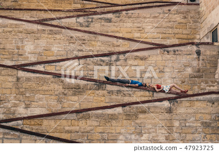 Man and woman laying on the city walls Man and woman laying on the city walls 47923725