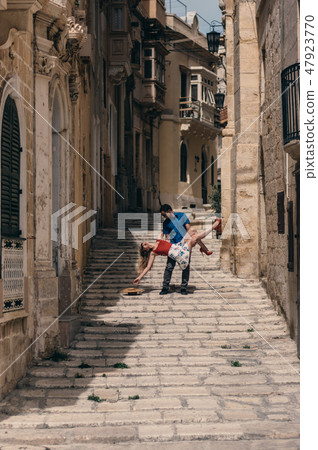 Man holding woman on hands on the street 47923770