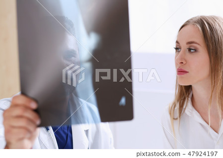 Mature male doctor hold in arm and look at xray photography 47924197