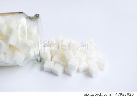 Glass bottle of sugar cubes on white. Glass bottle of sugar cubes on white. 47925029