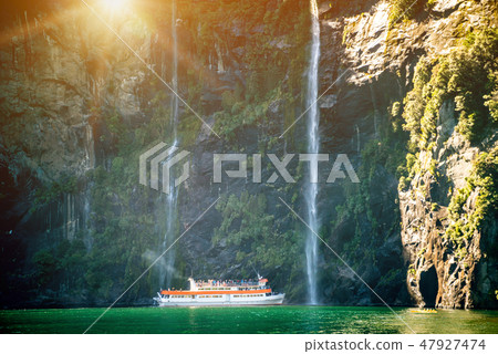 Scenic cruise approaches waterfall, Milford Sound. Scenic cruise approaches waterfall, Milford Sound. 47927474