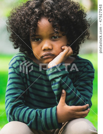Unhappy little african american kid in the park. 47927848