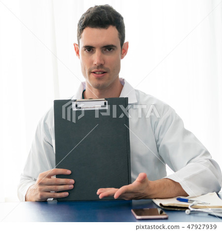 Doctor working in hospital office. 47927939