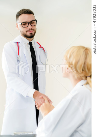 Doctor at hospital shakes hand with another doctor 47928032