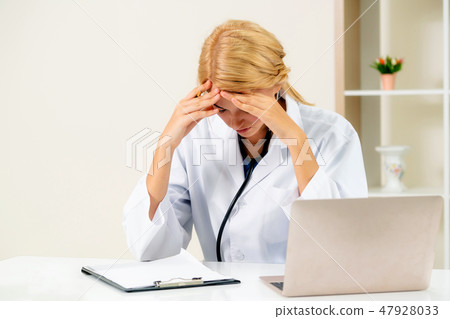 Serious doctor working in hospital office. 47928033