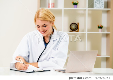 Young female doctor working in hospital office. 47928035