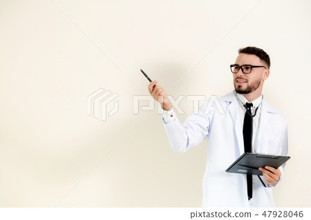 Male doctor points pen at empty wall copy space. Male doctor points pen at empty wall copy space. 47928046