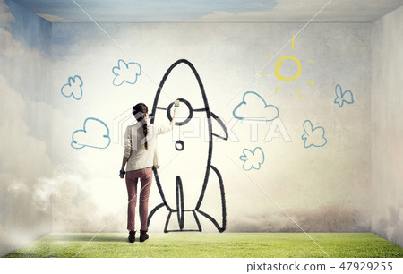 Girl drawing rocket 47929255
