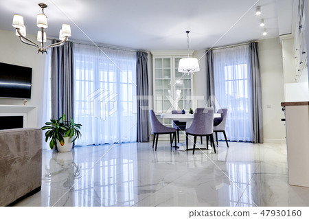 Minimalistic interior of living room in light tone with marble flooring, large windows and a table Minimalistic interior of living room in light tone with marble flooring, large windows and a table 47930160