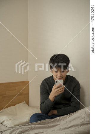 A boy who uses smartphone in bed sleep sleepy junior high school student high school student A boy who uses smartphone in bed sleep sleepy junior high school student high school student 47930243