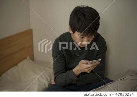 A boy who uses smartphone in bed sleep sleepy junior high school student high school student A boy who uses smartphone in bed sleep sleepy junior high school student high school student 47930254