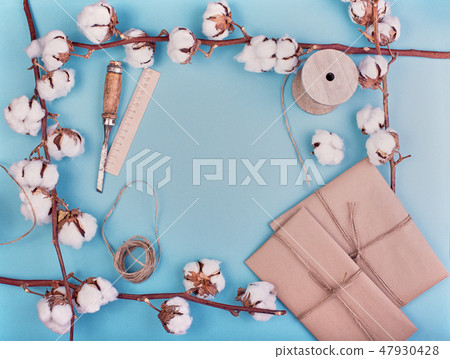 Flat lay of feminine blue background with branch of cotton flower. Cotton, gift boxes, jute rope Flat lay of feminine blue background with branch of cotton flower. Cotton, gift boxes, jute rope 47930428