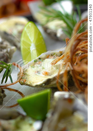 Seafood background. Oysters baked with cheese and lime close up. Italian cuisine with seafood. Food Seafood background. Oysters baked with cheese and lime close up. Italian cuisine with seafood. Food 47931140