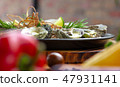 Oysters baked with cheese and herbs on plate at vegetable background. Seafood composition 47931141