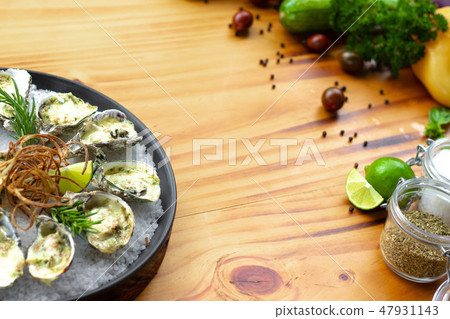 Oysters cooked with cheese and herbs on wooden copy space. Seafood composition. Italian cuisine with Oysters cooked with cheese and herbs on wooden copy space. Seafood composition. Italian cuisine with 47931143