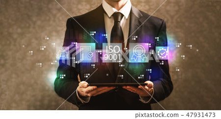 ISO 9001 with businessman holding a tablet computer ISO 9001 with businessman holding a tablet computer 47931473