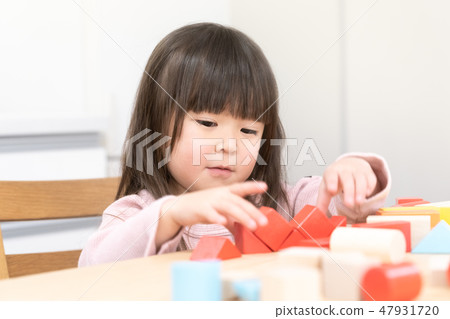 A girl playing with building blocks 47931720