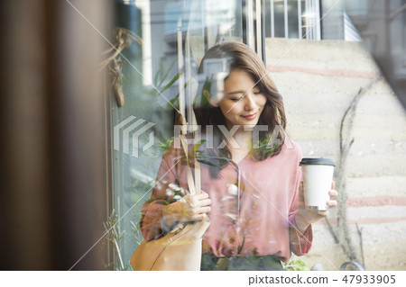 一個拿出咖啡離開商店的女人 一個拿出咖啡離開商店的女人 47933905