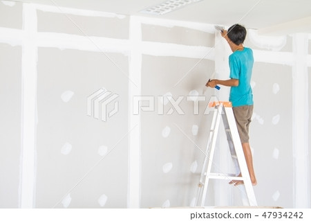 worker male on stair is putting gypsum plaster 47934242