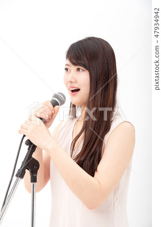 一個女人用麥克風唱歌 一個女人用麥克風唱歌 47934942