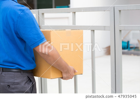 Delivery man holding a parcel and waiting recieved Delivery man holding a parcel and waiting recieved 47935045