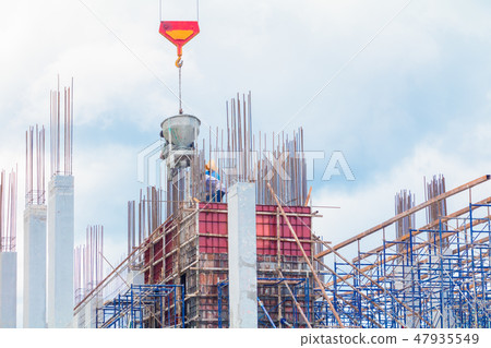 crane lifting concrete mixer container and worker 47935549