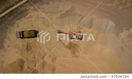 Aerial photo of excavator pours sand into the truck. 47936184