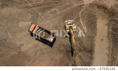 Aerial photo of excavator pours sand into the truck. Aerial photo of excavator pours sand into the truck. 47936199
