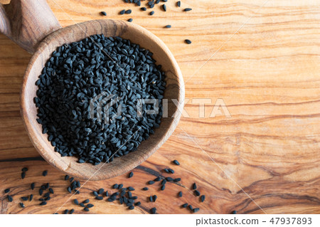 Black cumin seeds on a wooden spoon Black cumin seeds on a wooden spoon 47937893