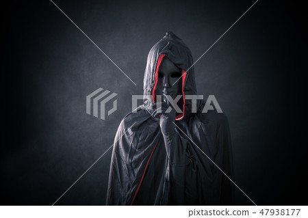 Scary figure with black mask in hooded cloak  47938177