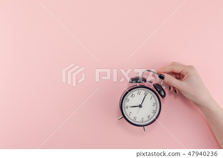 Female hand with alarm clock. Morning concept Female hand with alarm clock. Morning concept 47940236