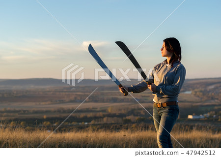 Girl on a high mountain trains with a machete 47942512